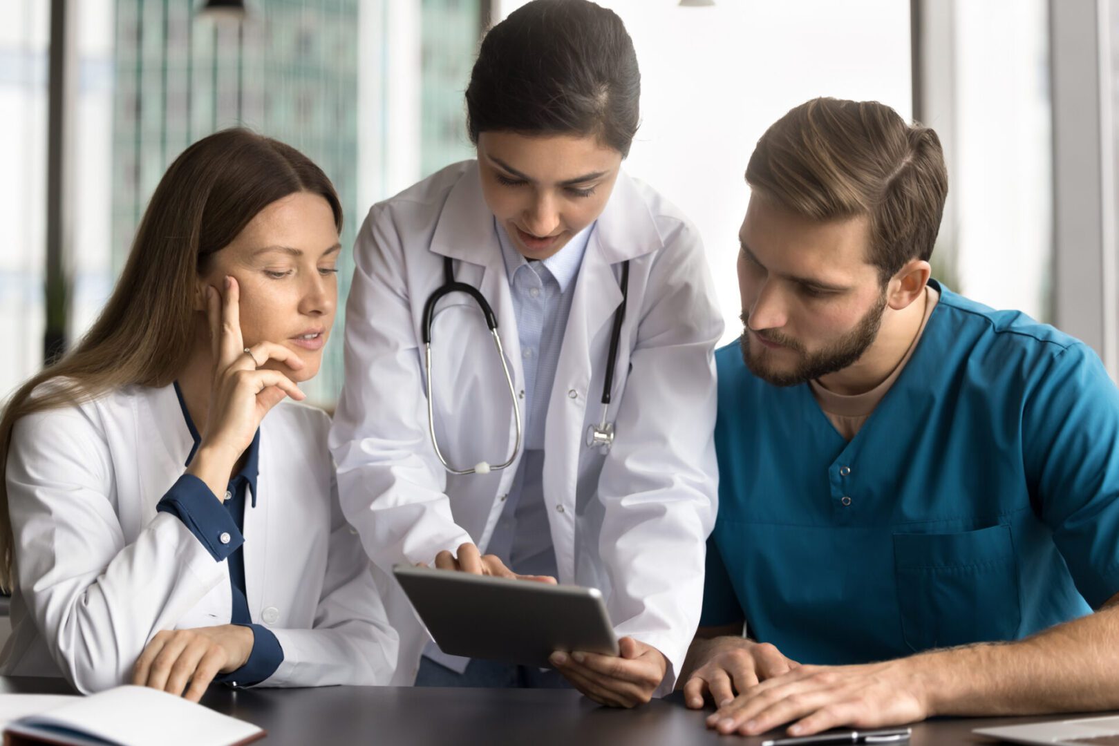 Doctors discussing information on a tablet.
